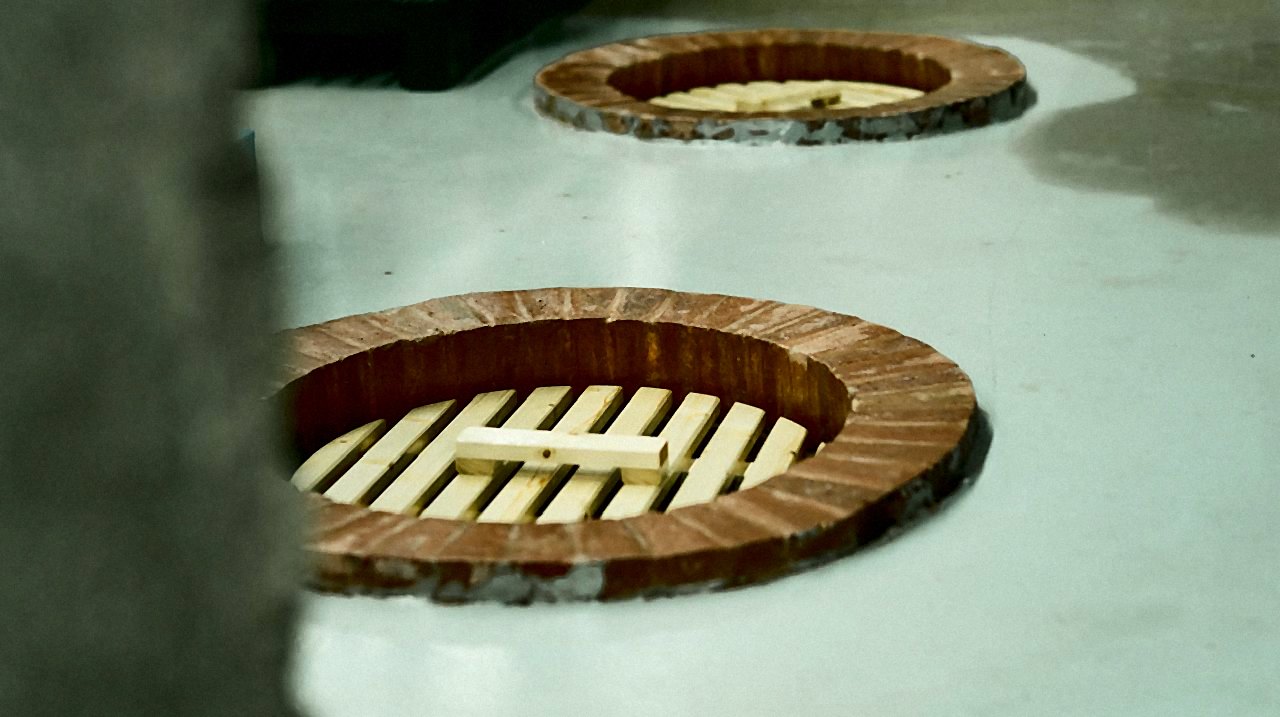 Qvevri openings set into the cellar floor